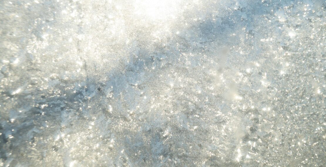 A luminous close-up of a sparkling water surface with bright reflections.