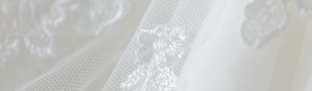 Delicate wedding dress detail close up of lace stitching